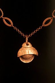 Copper pendant necklace with circular design.