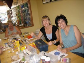 Women crafting and smiling at a table.