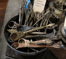 Decorative metal spoons in a black bowl.