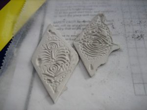 Textured clay pieces with intricate designs.