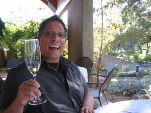Man celebrating with a glass outdoors.