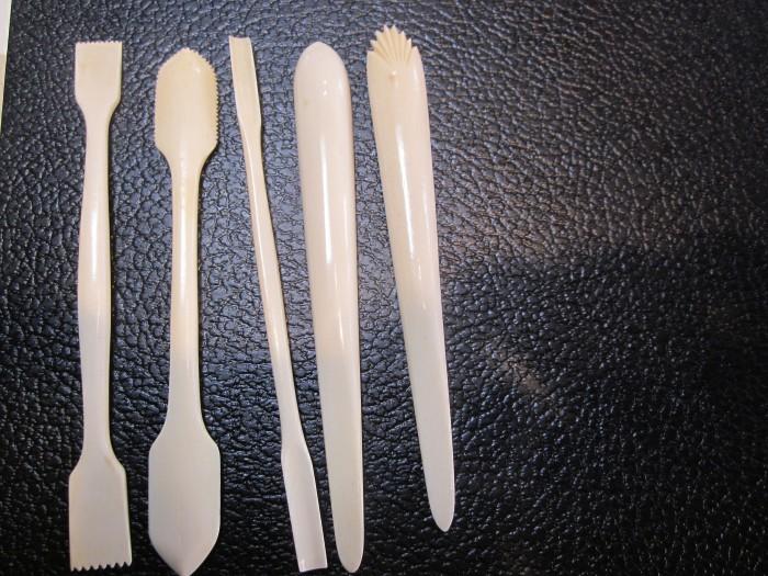 Five plastic sticks on a black surface.