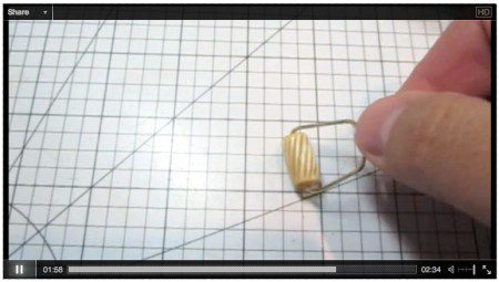 Hand holding a small cylindrical object.