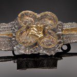 Ornate metallic brooch with floral design.