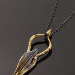 Gold and silver abstract pendant on chain.