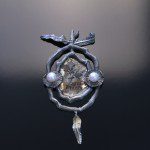 Ornate brooch with pearls and leaf design.
