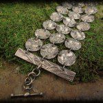 Silver coin bracelet on moss background.