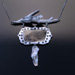 Artistic necklace with abstract silver design.