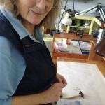 Woman smiling in a workshop setting.
