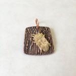 Square pendant with beetle design.