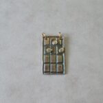 Rectangular silver pendant with grid design.
