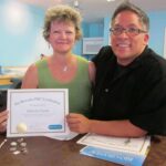 Two people smiling with a certificate.
