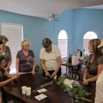 Group crafting activity around a wooden table.