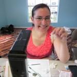 Person smiling, holding puzzle piece at desk.