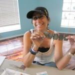 Smiling person holding a strip of photos.