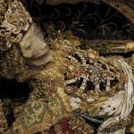 Ornate jeweled skeleton in elaborate gold attire.