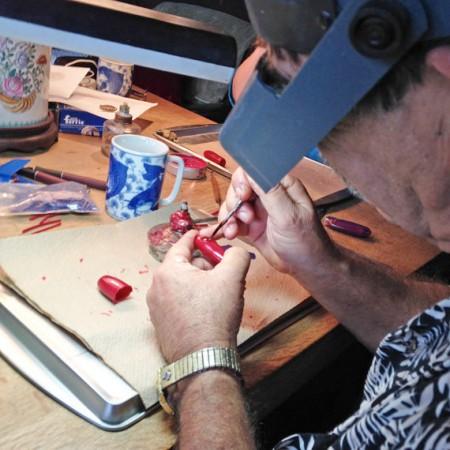 Man crafting model with magnifying headset.
