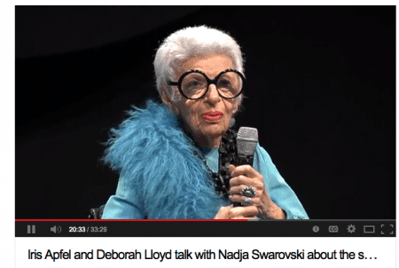 Elderly woman speaking into a microphone.