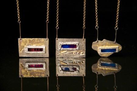 Geometric metal pendants with colorful inlays.