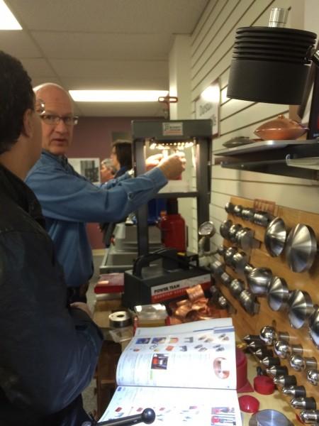 Man demonstrating tools in a workshop setting.