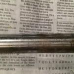 Metal rod on top of newspaper text.