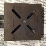 Metal plate on newspaper background.