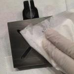 Gloved hand cleaning metal object with cloth.