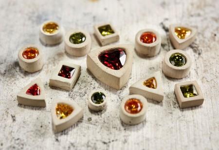 Colorful gemstones in various shapes on table.