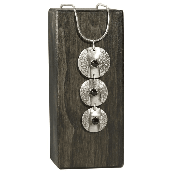 Textured silver necklace with circular pendants.