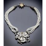 Pearl necklace with intricate coin pendant design.