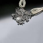 Silver heart pendant with pearl chains.