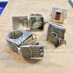 Silver rings with intricate designs on paper.