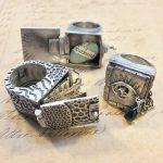 Silver rings with intricate, unique designs displayed.