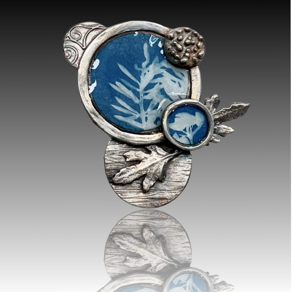 Artistic brooch with blue leaf design.