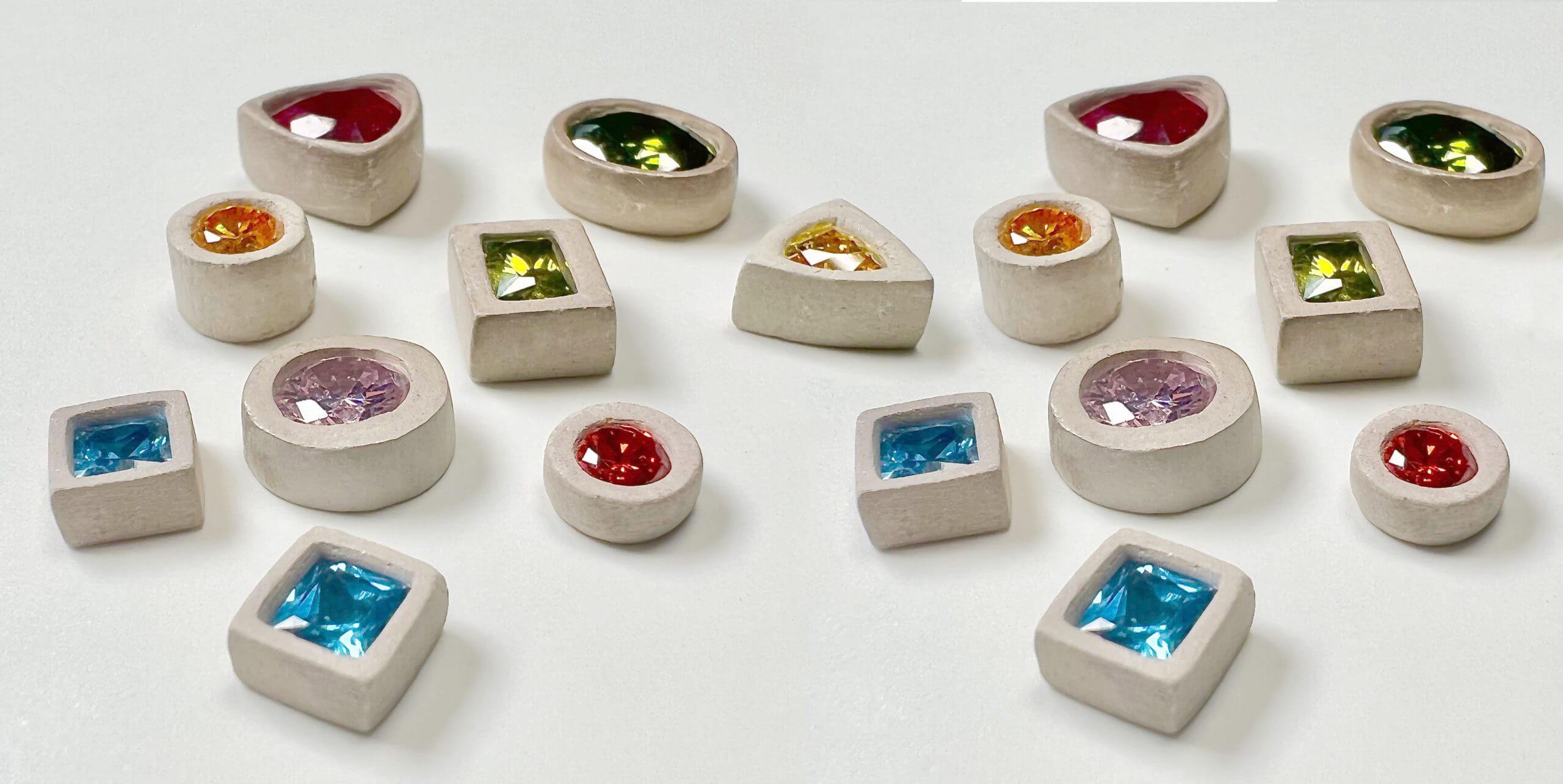 Colorful gemstones in various shapes and settings.